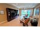 Living room with entertainment center and view to patio furniture and the outdoor space beyond at 2527 Terracina Dr, Venice, FL 34292