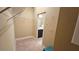 Carpeted walk-in closet with metal shelving, stool, and view to bathroom at 2527 Terracina Dr, Venice, FL 34292
