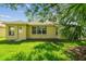Grassy backyard featuring exterior of home with door and windows at 2609 Rosehaven Dr, Wesley Chapel, FL 33544