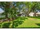 Lush backyard featuring mature trees, expansive green lawn, and privacy fence at 2609 Rosehaven Dr, Wesley Chapel, FL 33544