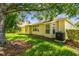 Beautiful backyard view of house featuring well-kept lawn and mature trees at 2609 Rosehaven Dr, Wesley Chapel, FL 33544