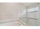 Bathroom with a tub and glass-enclosed shower featuring grab bars at 2609 Rosehaven Dr, Wesley Chapel, FL 33544