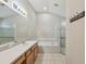 Well-lit bathroom with a bathtub, glass-enclosed shower, and a large vanity at 2609 Rosehaven Dr, Wesley Chapel, FL 33544