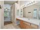 Bright bathroom featuring a light wood vanity with white countertops and tile flooring at 2609 Rosehaven Dr, Wesley Chapel, FL 33544