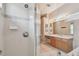Bright bathroom featuring glass-enclosed shower and light wood vanity at 2609 Rosehaven Dr, Wesley Chapel, FL 33544