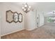 Dining room with chandelier and decorative mirrors, leads into living room and kitchen areas at 2609 Rosehaven Dr, Wesley Chapel, FL 33544