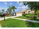 Inviting home with lush green lawn, mature palm trees, and a paved driveway at 2609 Rosehaven Dr, Wesley Chapel, FL 33544