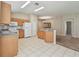 Spacious kitchen featuring wood cabinets, white appliances, and tile floors with flow into living space at 2609 Rosehaven Dr, Wesley Chapel, FL 33544
