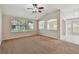 Spacious living room with carpet flooring, ceiling fan, and a view of the yard at 2609 Rosehaven Dr, Wesley Chapel, FL 33544