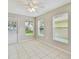 Bright living room with neutral paint, three windows, ceiling fan and tile flooring at 2609 Rosehaven Dr, Wesley Chapel, FL 33544