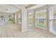 Open living area with tile floors, multiple windows and view of kitchen area at 2609 Rosehaven Dr, Wesley Chapel, FL 33544
