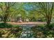 Community playground with mature trees, walking path and play structures for outdoor fun at 2609 Rosehaven Dr, Wesley Chapel, FL 33544