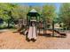 Community playground with green and tan play structure and wood chip ground covering at 2609 Rosehaven Dr, Wesley Chapel, FL 33544