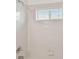 Bright white tiled shower with window letting in natural light at 2609 Rosehaven Dr, Wesley Chapel, FL 33544