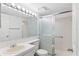 Well-lit bathroom with a large mirror, a sliding door shower, and classic white fixtures for a clean look at 2699 Pine Ridge E Way # H2, Palm Harbor, FL 34684