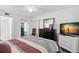 Inviting bedroom with an ensuite bathroom, wood-look floors, and a dresser with a sailboat on the TV at 2699 Pine Ridge E Way # H2, Palm Harbor, FL 34684