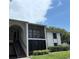 White condo building with screened balconies and mature landscaping at 2699 Pine Ridge E Way # H2, Palm Harbor, FL 34684