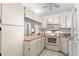 Well-lit kitchen with white cabinets and countertops at 2699 Pine Ridge E Way # H2, Palm Harbor, FL 34684