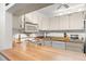 Bright kitchen featuring white appliances and cabinetry, complemented by wood countertops and a modern microwave at 2699 Pine Ridge E Way # H2, Palm Harbor, FL 34684