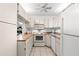 Bright kitchen featuring white cabinetry, and efficient appliances at 2699 Pine Ridge E Way # H2, Palm Harbor, FL 34684