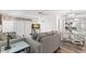 Comfortable living room adjacent to dining area, featuring a plush grey sofa and modern decor at 2699 Pine Ridge E Way # H2, Palm Harbor, FL 34684