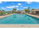 Resort style pool with lounge chairs and palm trees overlooking the water at 2699 Pine Ridge E Way # H2, Palm Harbor, FL 34684