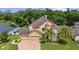 Aerial view of a beautiful two-story home showcasing a manicured lawn, mature trees, and a brick driveway at 3148 Watermark Dr, Wesley Chapel, FL 33544