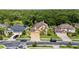 Aerial view of a suburban home with a manicured lawn, mature trees, and community at 3148 Watermark Dr, Wesley Chapel, FL 33544