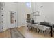 Bright dining room featuring a modern chandelier, a large dining table, and a decorative front door at 3148 Watermark Dr, Wesley Chapel, FL 33544