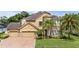 Beautiful home exterior with a manicured lawn, mature palms, and a circular driveway at 3148 Watermark Dr, Wesley Chapel, FL 33544