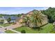 Lush front yard with tropical palms and a circular driveway leads to an attractive stucco home with a three-car garage at 3148 Watermark Dr, Wesley Chapel, FL 33544