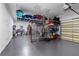 Spacious garage featuring ample storage, epoxy flooring, and organized shelving at 3148 Watermark Dr, Wesley Chapel, FL 33544