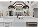 Bright, white kitchen with farmhouse sink, pendant lighting, and a large window with cathedral ceiling at 3148 Watermark Dr, Wesley Chapel, FL 33544