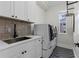 Modern laundry room with front-load washer and dryer, stylish tile backsplash, and ample storage at 3148 Watermark Dr, Wesley Chapel, FL 33544