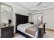 This primary bedroom boasts natural lighting, tray ceiling, and an ensuite bathroom with a sliding door at 3148 Watermark Dr, Wesley Chapel, FL 33544