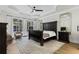 Spacious main bedroom featuring tray ceiling, abundant natural light, and dark wood furniture at 3148 Watermark Dr, Wesley Chapel, FL 33544