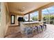 Covered outdoor kitchen with a bar and seating area for entertaining at 3148 Watermark Dr, Wesley Chapel, FL 33544