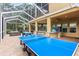 Enclosed patio features ping pong table, outdoor bar, and foosball table at 3148 Watermark Dr, Wesley Chapel, FL 33544