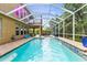 Relaxing screened-in pool area with turquoise water, hammock, and a hot tub overlooking the lush landscape at 3148 Watermark Dr, Wesley Chapel, FL 33544