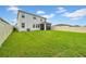 Large backyard with lush green grass, modern fence, and screened lanai at 32136 Conchshell Sail St, Wesley Chapel, FL 33545