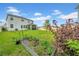 Expansive backyard featuring lush lawn, garden bed, and privacy fence, with home exterior at 32136 Conchshell Sail St, Wesley Chapel, FL 33545