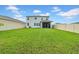 Spacious backyard with lush green grass, privacy fence, and covered patio at 32136 Conchshell Sail St, Wesley Chapel, FL 33545