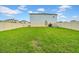 Wide backyard with lush green grass, privacy fence, and young landscaping at 32136 Conchshell Sail St, Wesley Chapel, FL 33545