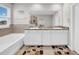 This bathroom offers a dual vanity, storage, granite counters, and a tiled tub at 32136 Conchshell Sail St, Wesley Chapel, FL 33545
