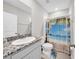 Bathroom featuring granite countertop, toilet, shower with decorative curtain and tile floor at 32136 Conchshell Sail St, Wesley Chapel, FL 33545