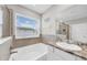 Bright bathroom features a soaking tub, granite countertop vanity, and shower with glass door at 32136 Conchshell Sail St, Wesley Chapel, FL 33545