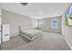 This carpeted bedroom offers neutral walls, natural light, and a queen bed, along with a wall-mounted television at 32136 Conchshell Sail St, Wesley Chapel, FL 33545