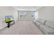 Large carpeted bonus room with large windows, modern sofa, and a television at 32136 Conchshell Sail St, Wesley Chapel, FL 33545