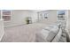 Spacious bonus room features carpet, ample natural light, and a modern sofa at 32136 Conchshell Sail St, Wesley Chapel, FL 33545