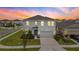 Beautiful two-story home with a well-manicured lawn and a two-car garage at sunset at 32136 Conchshell Sail St, Wesley Chapel, FL 33545